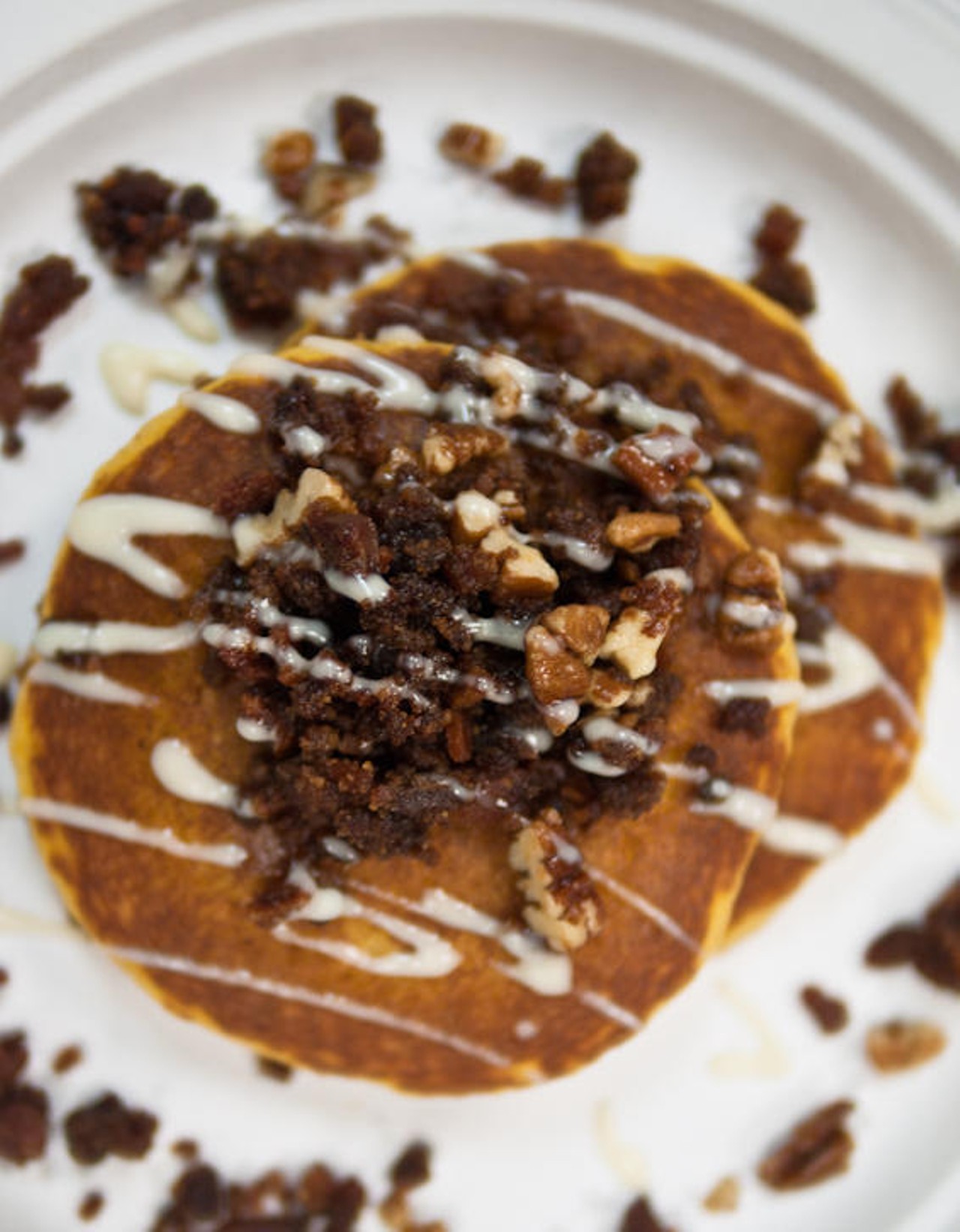 Spicy, sweet, and savory sweet potato pancakes topped with praline and bacon crumble and Kentucky bourbon whiskey sauce served up by Perk Eatery in Scottsdale, Arizona.