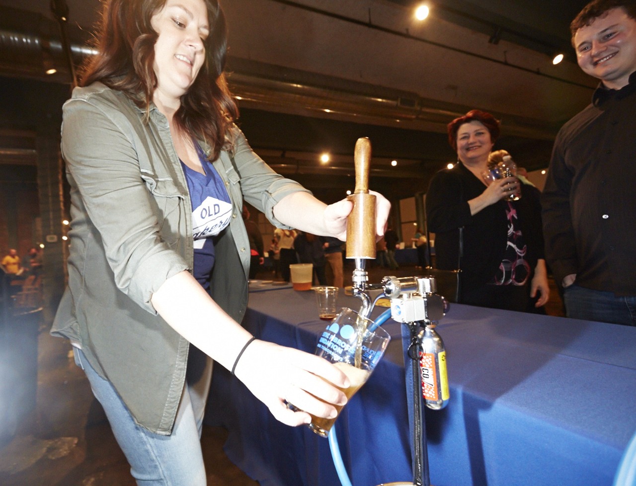Kayla Knoll, from Old Bakery Beer, pours a beer for mother and mon Laura and Brian Hunter.