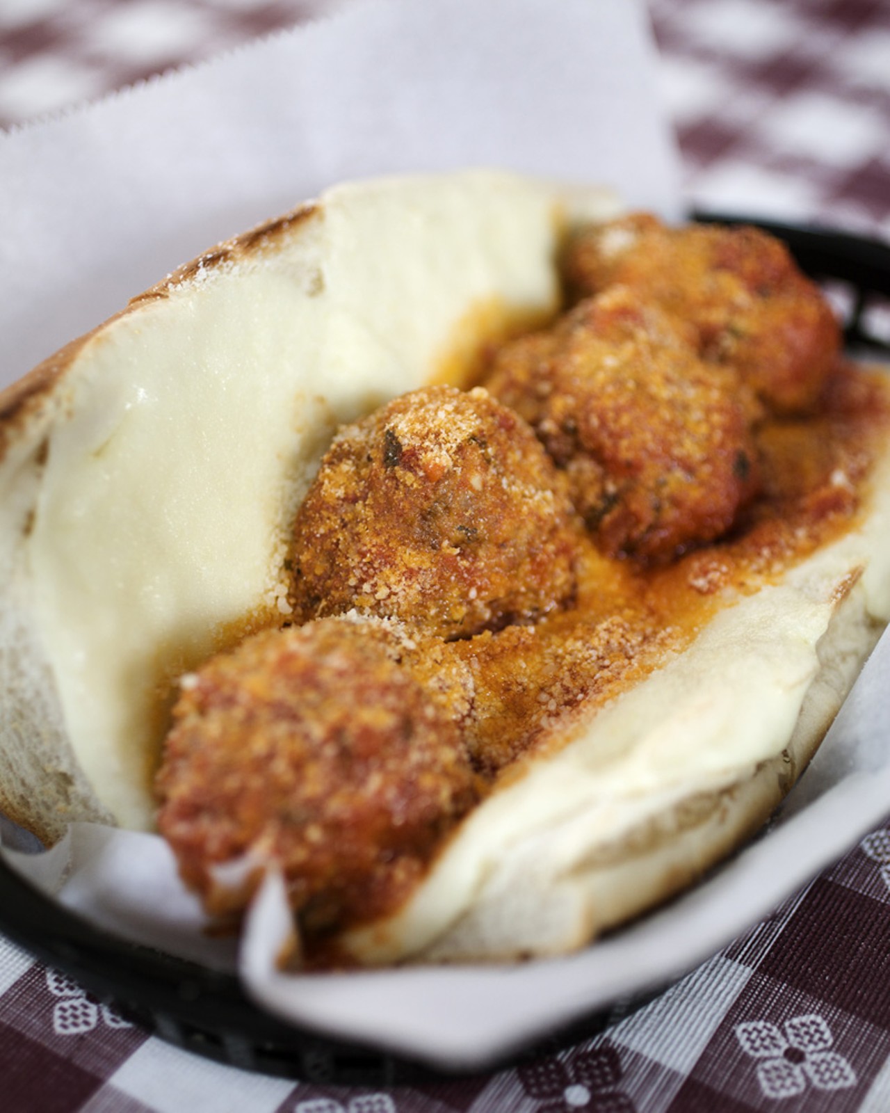 The Meatball Sub is prepared with housemade meatballs, simmered in marinara sauce, topped with provolone and parmigiano cheeses.