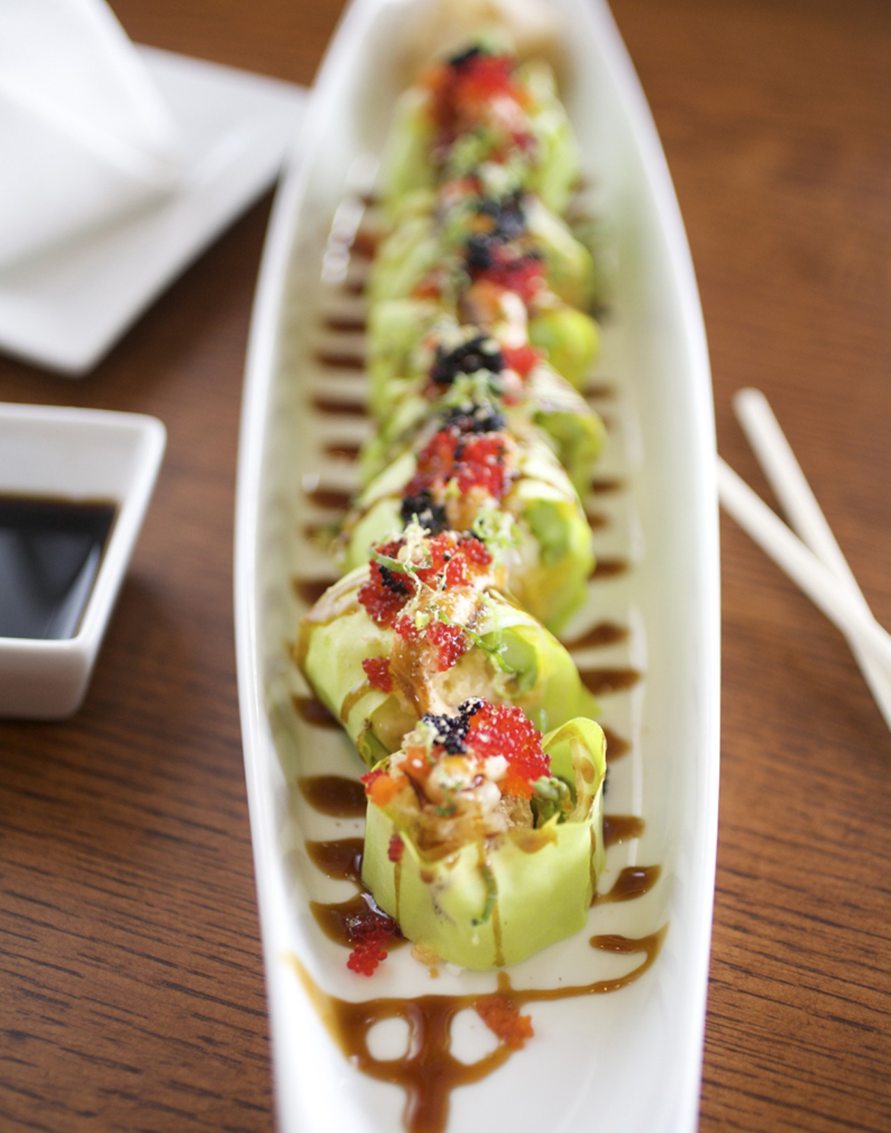The Crunch Roll is shrimp tempura, cream cheese, asparagus, cucumber, tempura crunch, lettuce, rolled with rice paper and topped with tobiko and eel sauce.