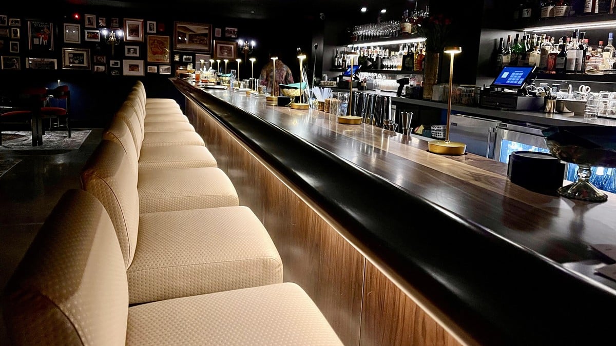 None of the Above features a custom-built 10-seat wooden bar with wall-spanning mirrors and an extensive spirits collection.