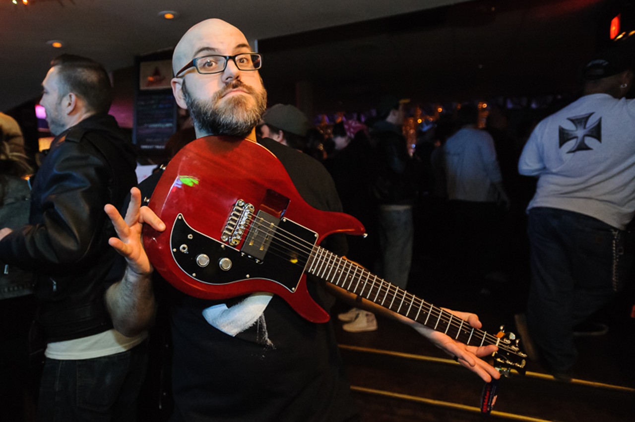 Organizer Justin Deming shows off a guitar, which was raffled off to raise money to cover Lundquist's medical bills.