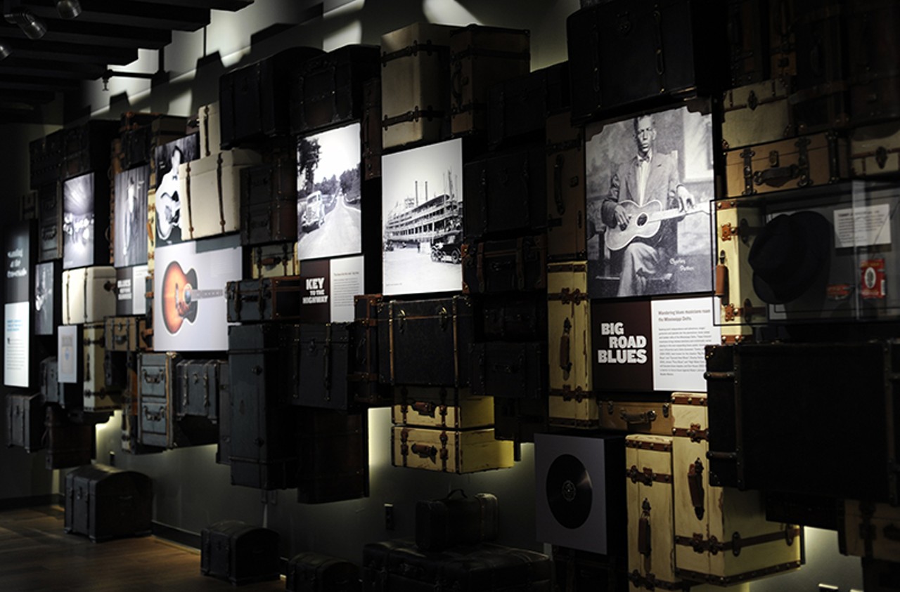 The suitcase wall symbolizes the migration of blues music from the Mississippi Delta to other parts of the United States.