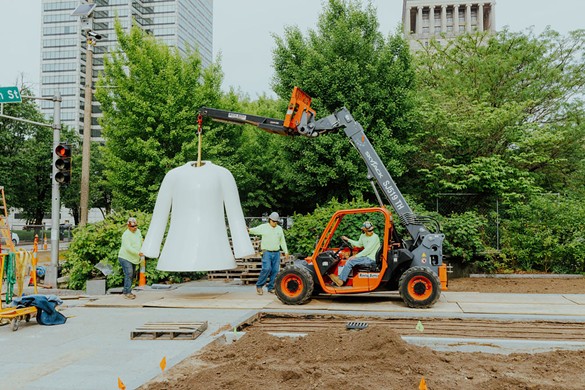 Workers lift a key piece of a new sculpture, White Ghost, in place at Citygarden.