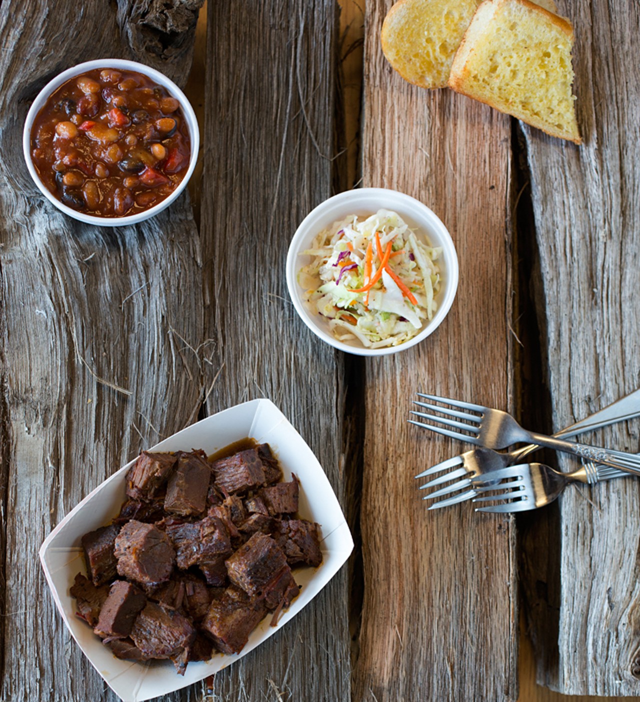 "Burnt Ends," served with garlic bread and a choice of two sides. Here, they are crispy cole slaw and baked beans, made with sweet peppers and pulled pork.