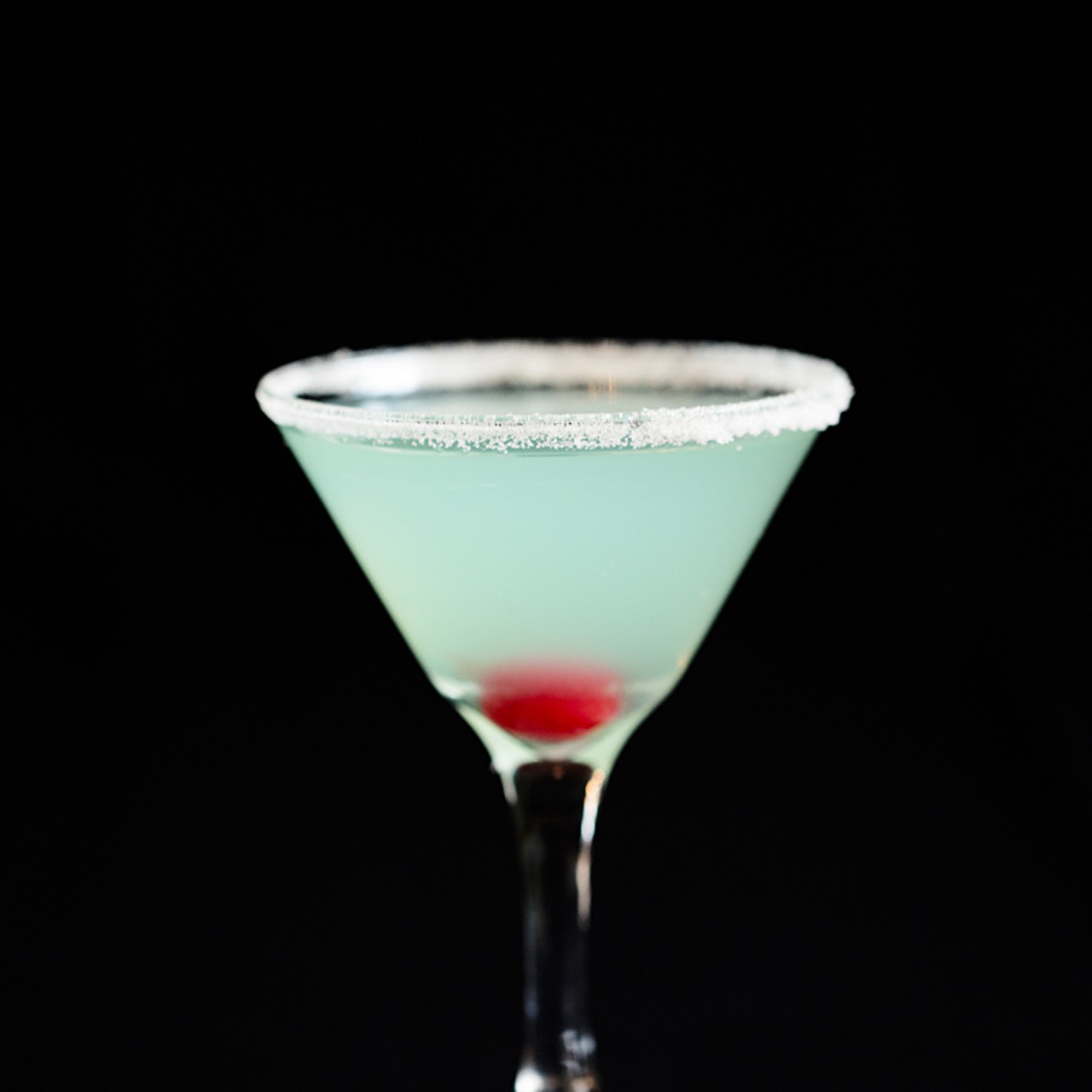 The Blue Illusion: Absolut Mandrin Vodka, Hpnotiq and sweet & sour mix, served in a glass with a sugared rim.