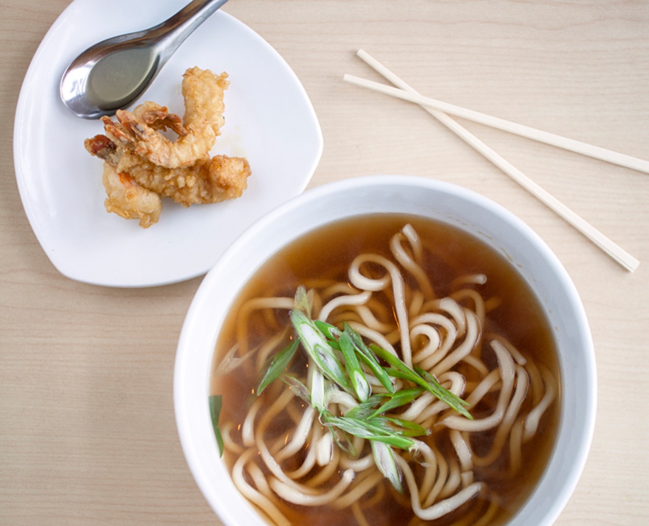 Tempura Udon Soup is served in a light soy broth, topped with green onions and served with tempura shrimp.