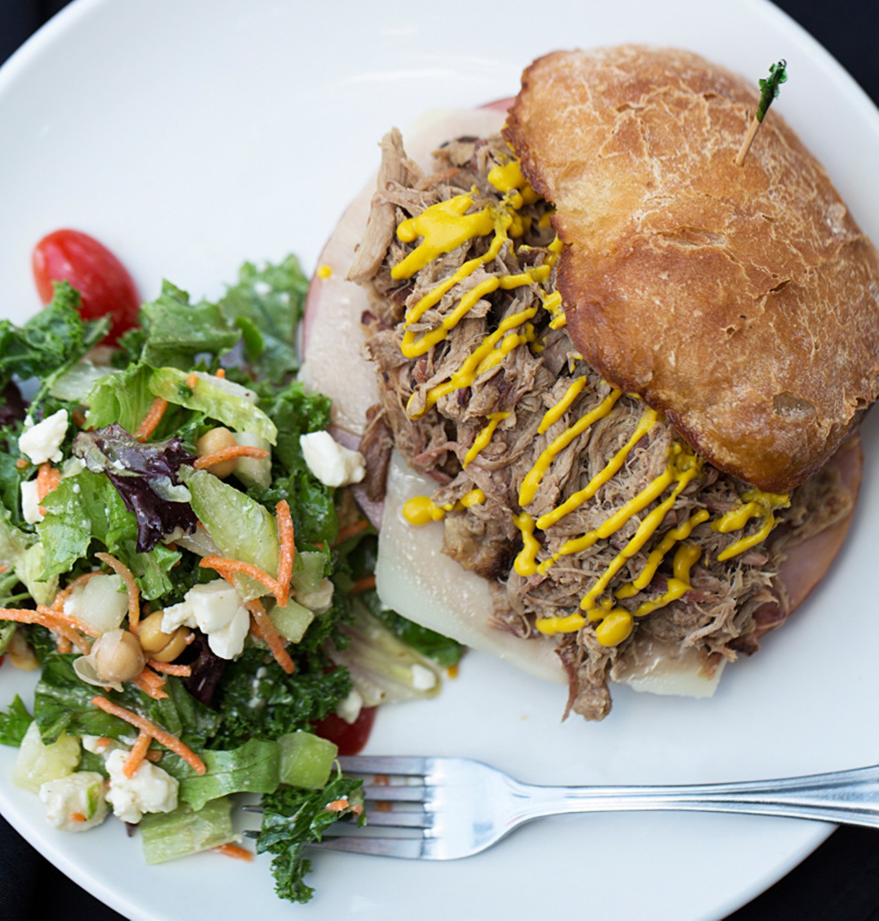 The Cuban sandwich brings pulled pork topped with Swiss cheese, ham, pickles and mustard. It's shown here with a side O-Line's chopped salad of mixed greens, kale, cucumber, celery, carrots, onions, tomato, chickpeas, feta and white balsamic vinaigrette.
