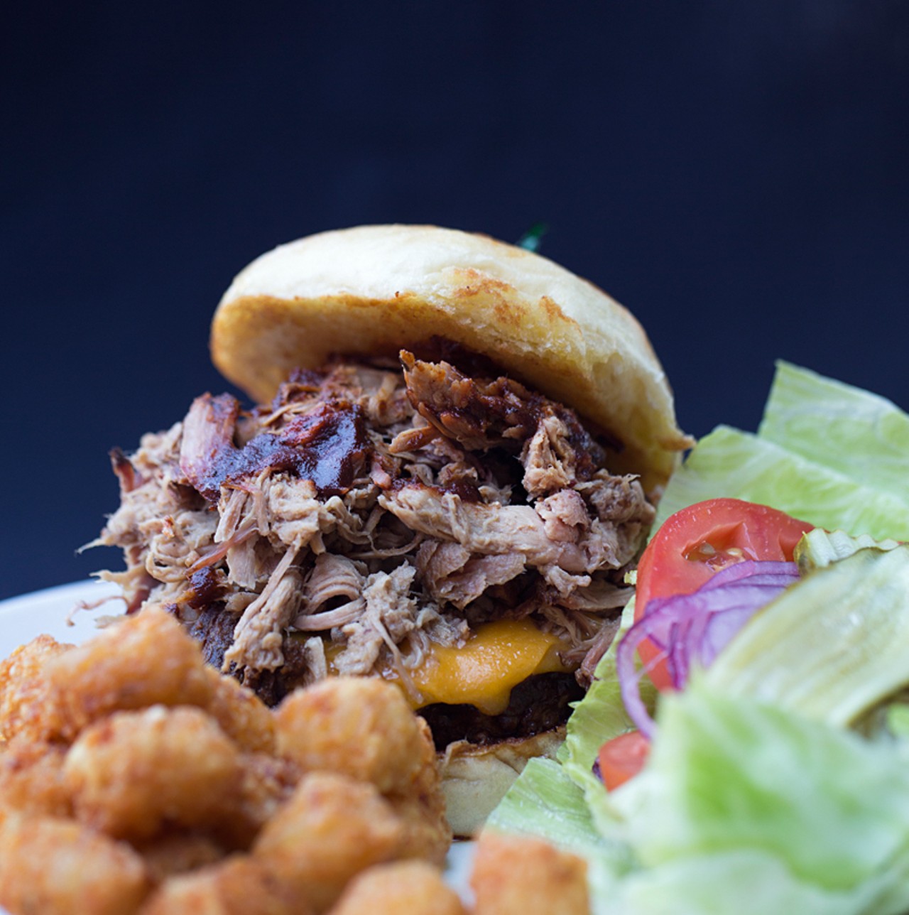 The "Philthy" burger is dipped in barbecue sauce and topped with cheddar cheese. Though pulled pork is shown here, diners have their choice of beef brisket, pulled pork or pulled chicken.