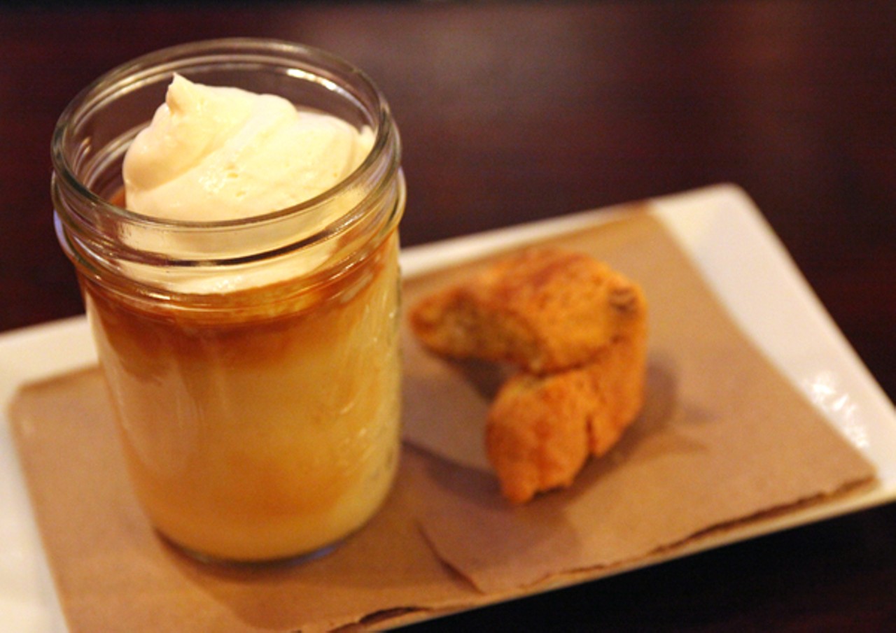 A Butterscotch Budino with whipped creme fraiche and homemade almond biscotti.