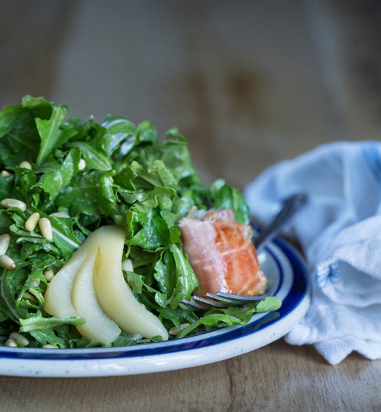 The poached-pear salad is arugula topped with goat cheese, prosciutto, pine nuts, pear vinaigrette and cinnamon.