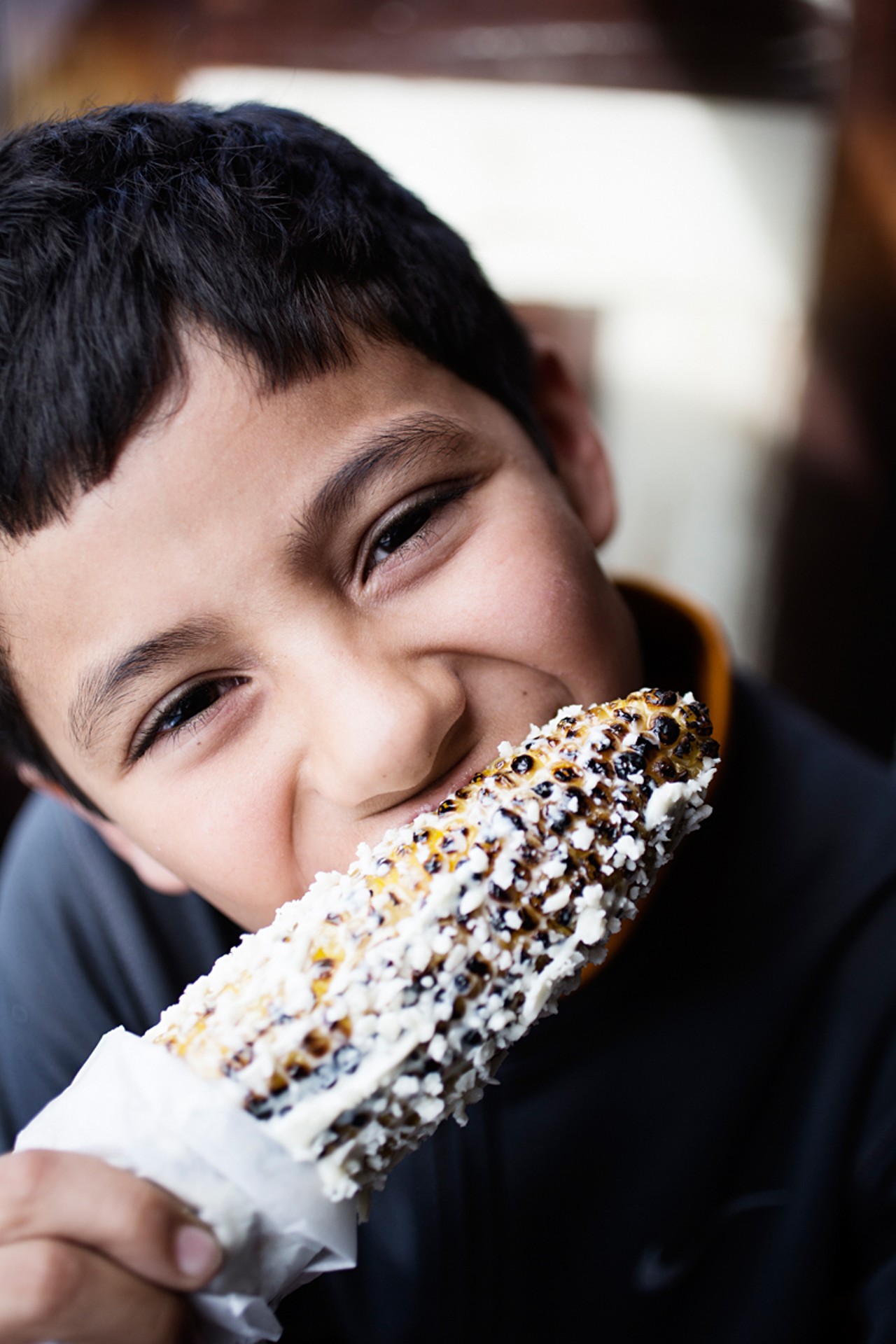 Owner and chef Jason Tilford's ten-year-old son, Julian, eating some roasted street corn.