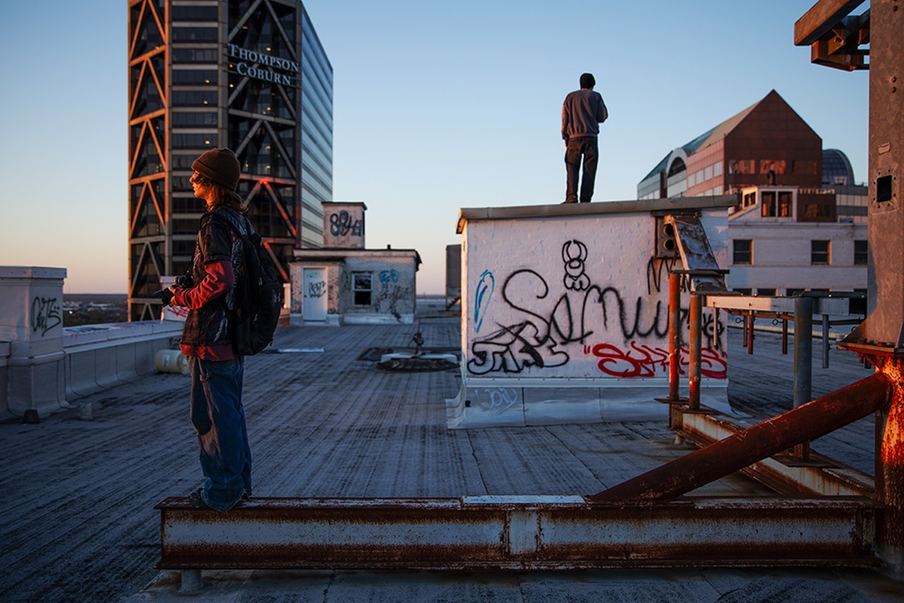 Urban explorers watch the sun set from the roof of the Railway Exchange Building in downtown St. Louis.