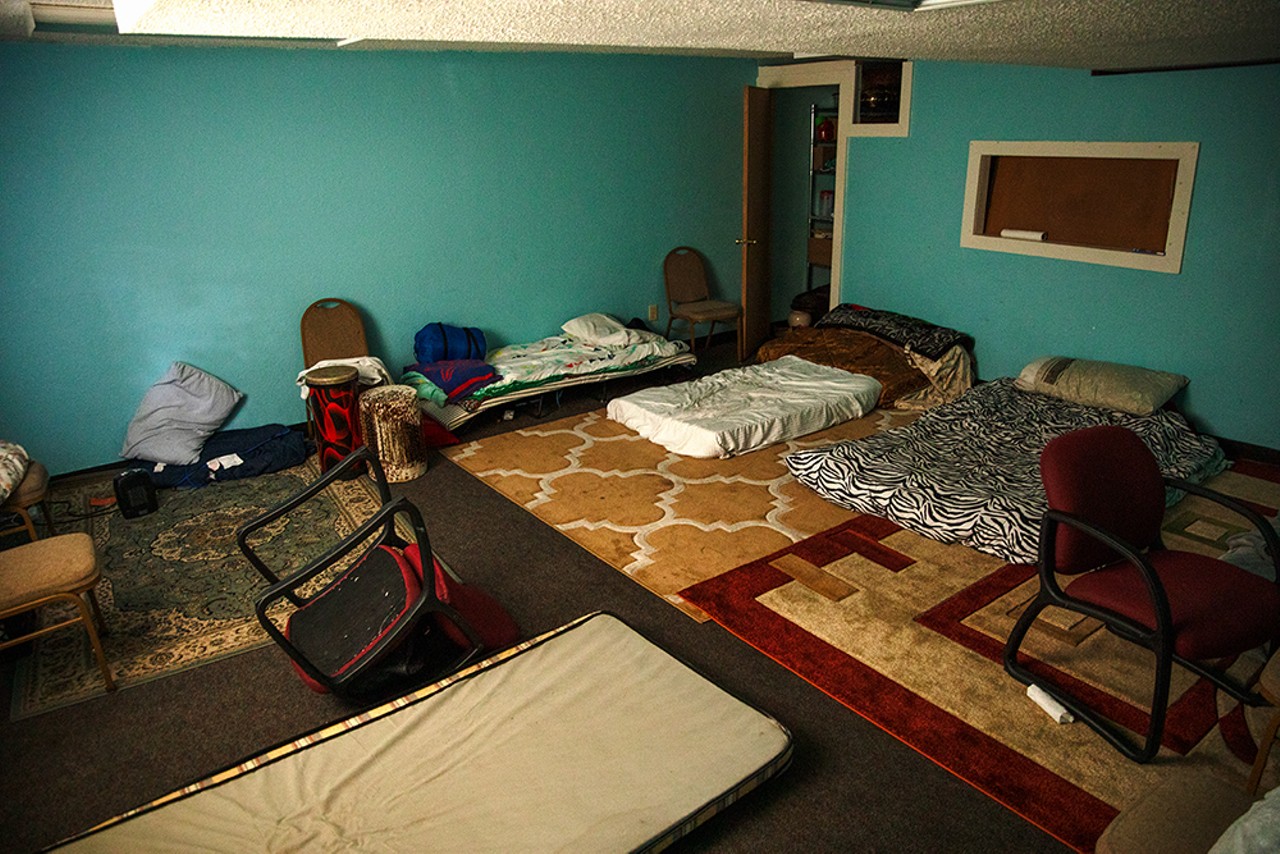 Beds and personal items fill a room in the basement of Mount Of Olives Ministry.