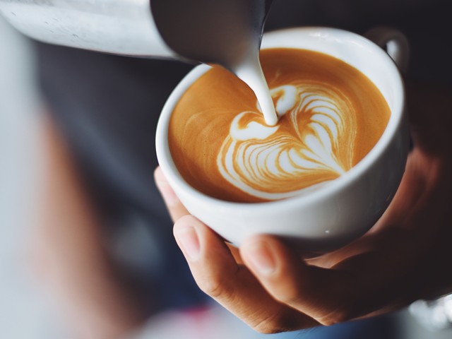 A barista creates latte art.