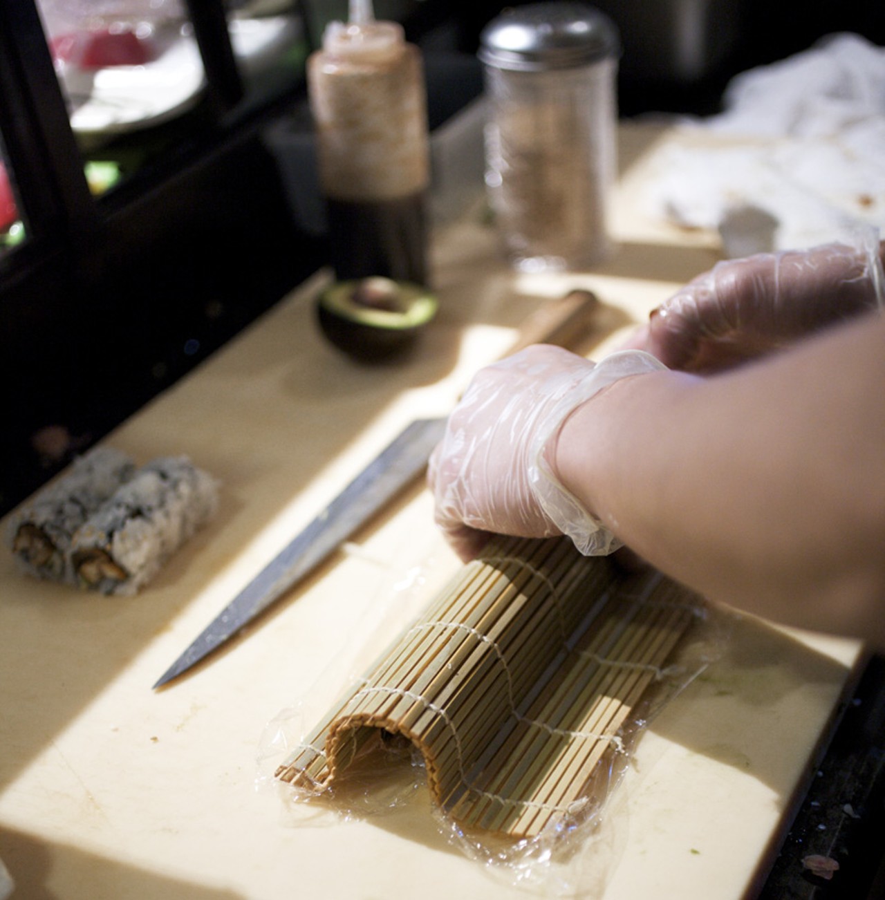 Sushi Chef Qi Dong making a roll with the typical bamboo mat.