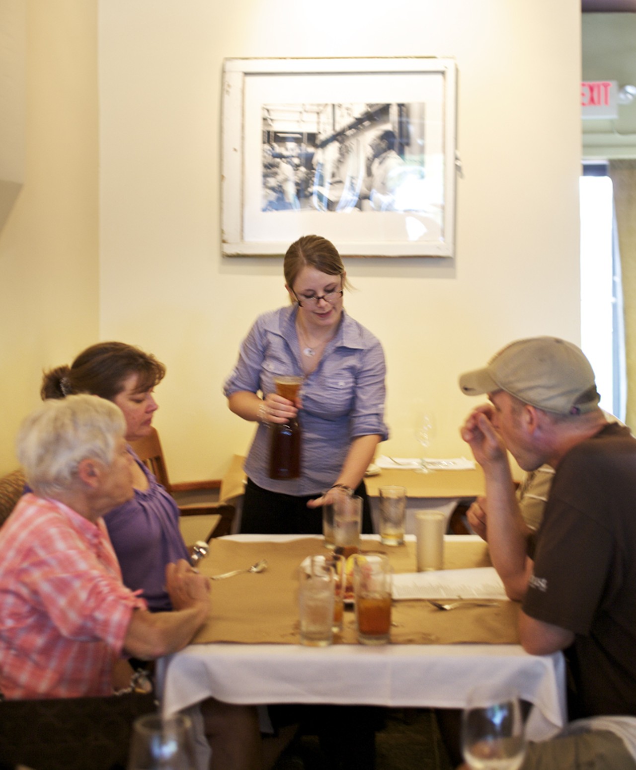 Server Tiffany Diering refilling glasses and going over dessert options with customers during lunch at Farmhaus.