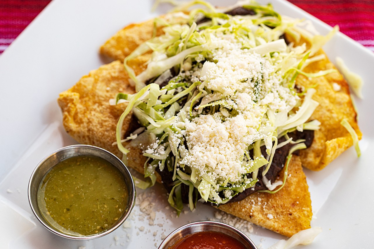 Empanadas fritas — two handmade fried corn tortillas stuffed with Oaxaca cheese or chicken, topped with refried black beans, cabbage, queso fresco and salsa.