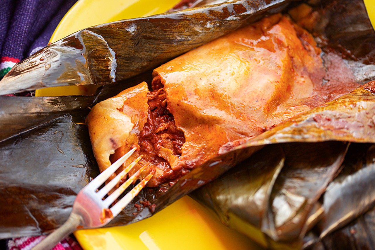 Tamales made with fresh corn masa filled with chicken and mole sauce, wrapped in plantain leaves.
