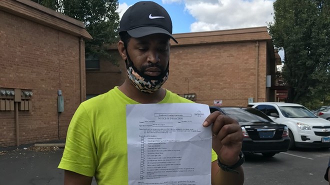 Terrell Porter is holding the letter his wife Janica Washington received from Sansone Group, the owner of Southwest Crossing apartments. The letter informed the couple they had violated tenant rules because of what she said in an RFT story published in August.
