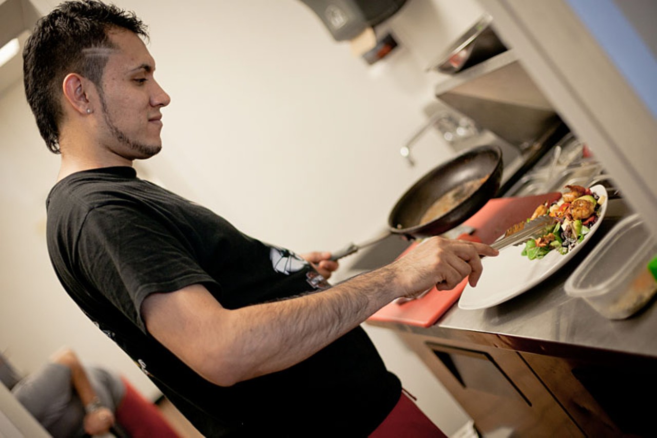Antonio Calderon prepares the house salad with shrimp.