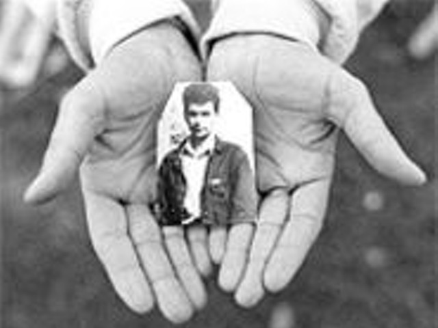 One of the two images visitors to the Missouri Historical Society will be presented with: Muska Oric's hands holding a photograph of her husband, Haso, missing since Srebrenica's fall in 1995.