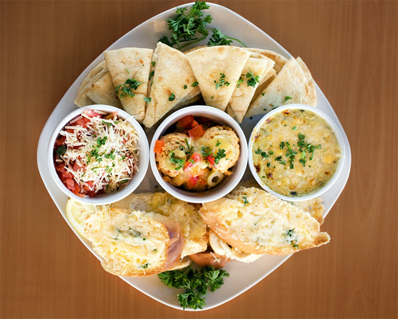 The Dip Trio appetizer is bruschetta, hummus and spinach artichoke dip served with warm pita and crispy crostinis.