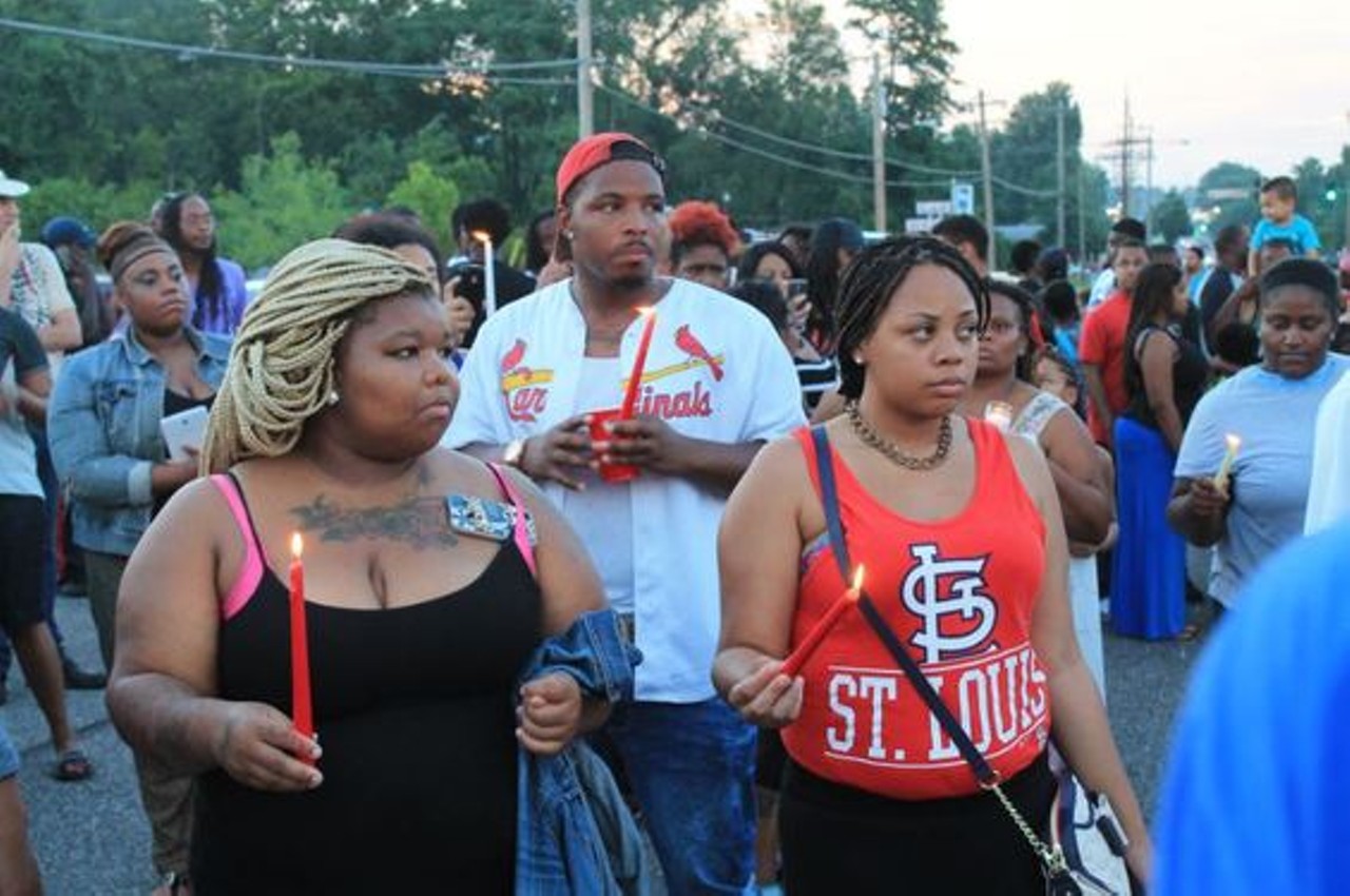 On August 10 in Ferguson, protesters held a vigil for Michael Brown. The event started out peacefully, with many people holding signs and candles as they faced hundreds of cops in riot gear. But as the night wore on, vigil candle lights gave way to smashed windows. Read "Peaceful Protest for Mike Brown Before Riot Police and Looting Takes Over."