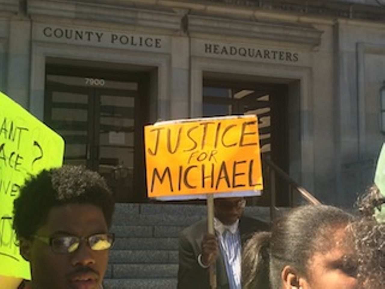 The demonstration on August 12 began outside the Buzz Westfall Justice Center with civil-rights activist Anthony Shahid using a pair of stuffed dogs and a noose around his neck as props to drive home his message. Read "Clayton Protest Over Michael Brown's Killing Stresses Peaceful Solution to Unrest."