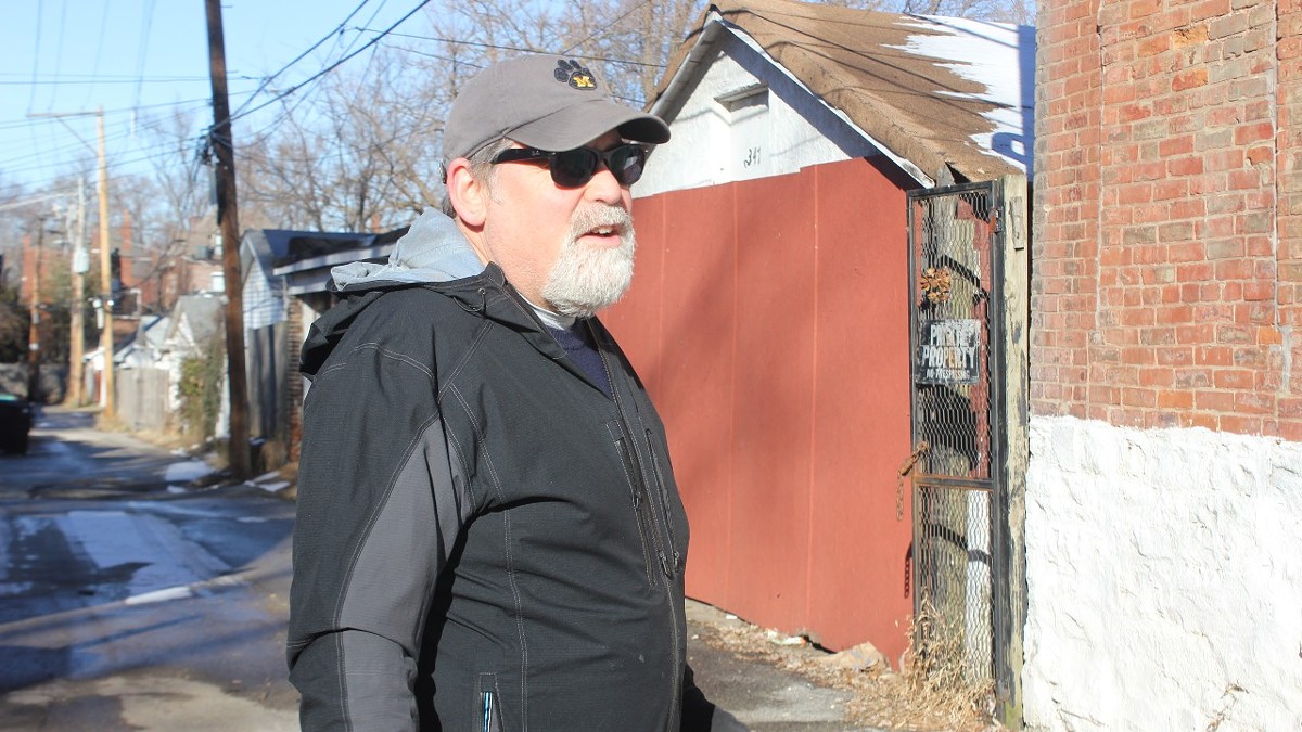 Tower Grove East resident Joseph Goodman stands in the alley between his home and one owned by Dara Daugherty.