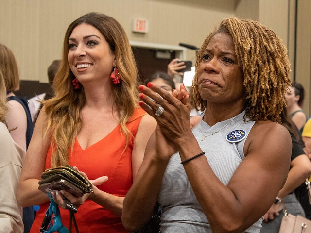 Dawn Rattan, right, cries and applauds Aug. 2, 2022, at the Kansas for Constitutional Freedom watch party after learning Kansans had defeated a constitutional amendment to remove abortion rights. (Lily O’Shea Becker/Kansas Reflector)