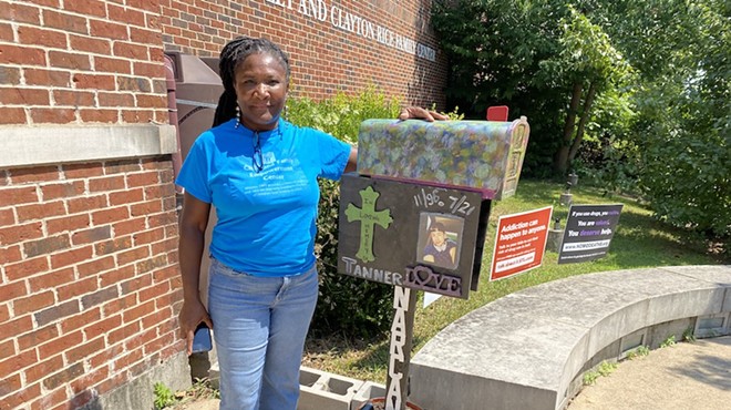 Marsha Hawkins-Hourd of the Child and Family Empowerment Center next to a Narcan station.