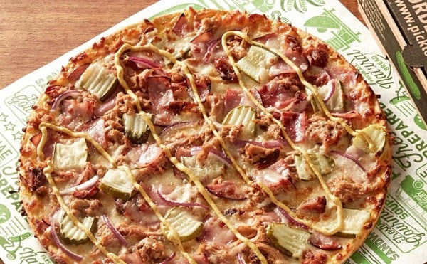 The Pickled Cuban pizza includes yellow-mustard sauce, smoked ham, pulled pork, cheese, bacon, onions, a spicy brown mustard drizzle and pickles.