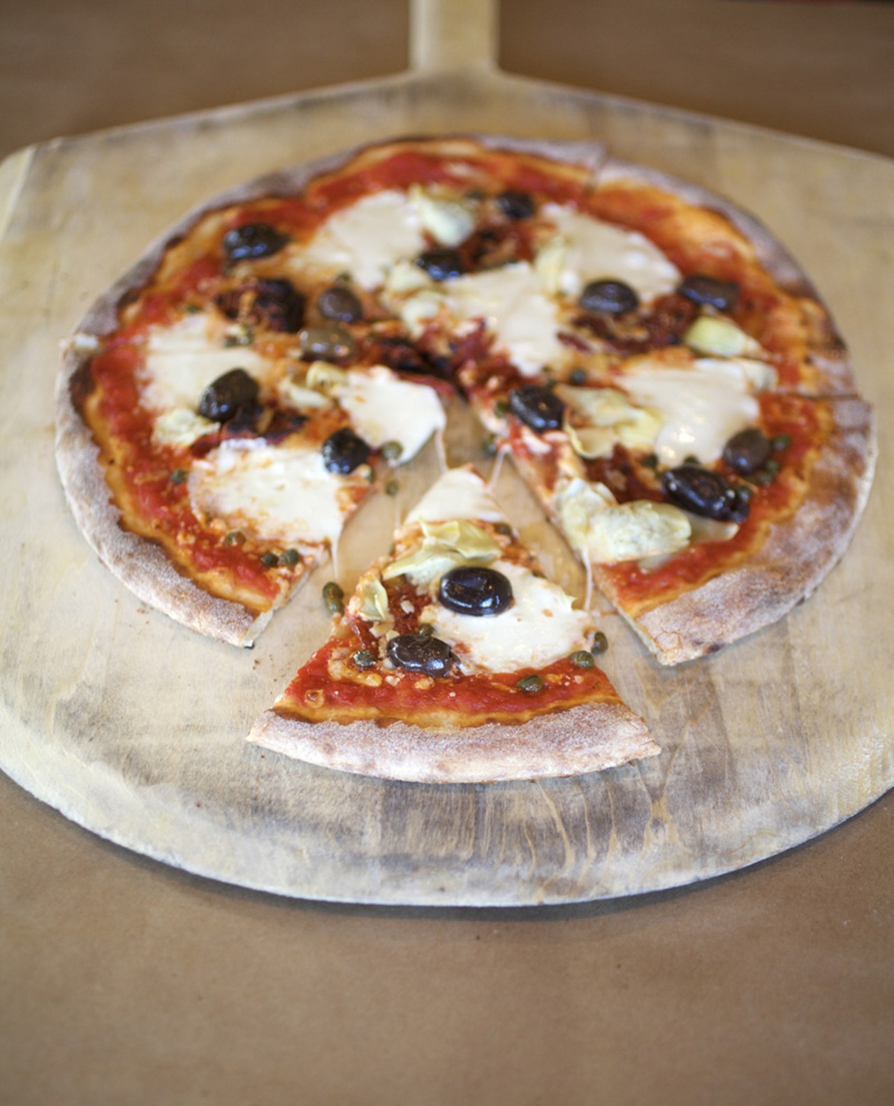 The Mediterranean Pizza is prepared with tomato sauce, sun dried tomatoes, kalamata olives, capers, feta, mozzarella and artichoke hearts.