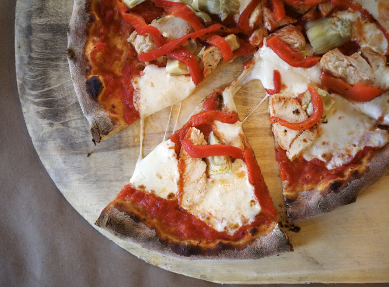 The Tivoli pizza is fresh pizza dough topped with tomato sauce, artichoke hearts, chicken, red peppers and fresh mozzarella.