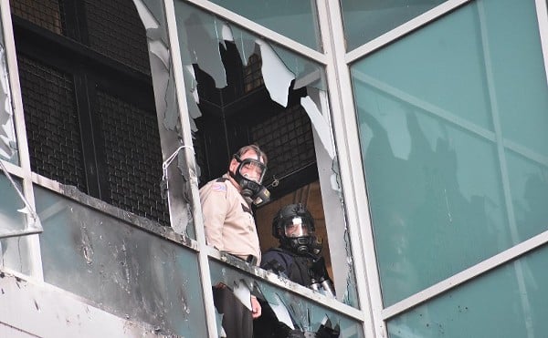 A St. Louis sheriff's deputy and police SWAT supervisor look out of shattered window on February 6, 2021, at the City Justice Center.