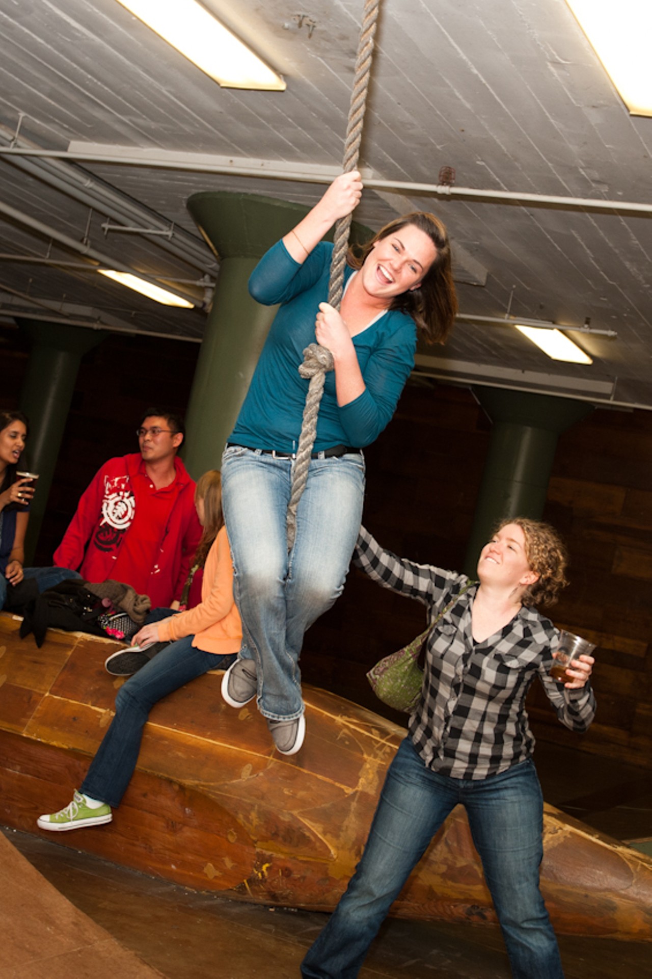 A RFT party attendee gets a helpful nudge from a friend while swinging from a rope at the City Museum.
