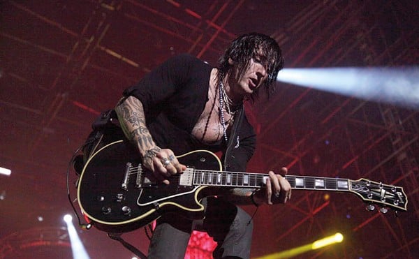 Richard Fortus plays guitar on stage.