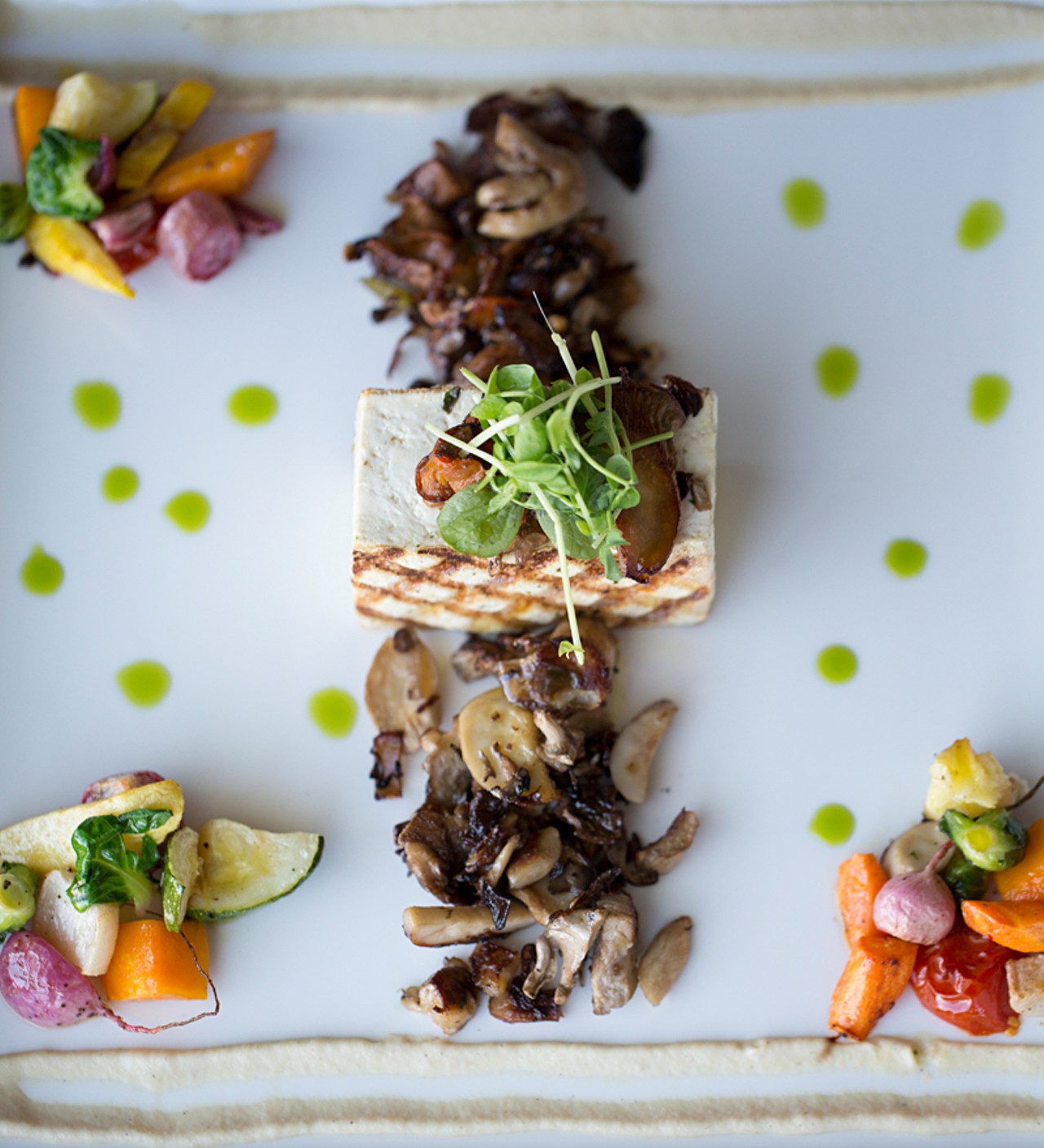 The "Marinated, Pressed and Grilled Tofu" is constructed from roasted Ozark mushrooms, petit root vegetables and two celery coulis.