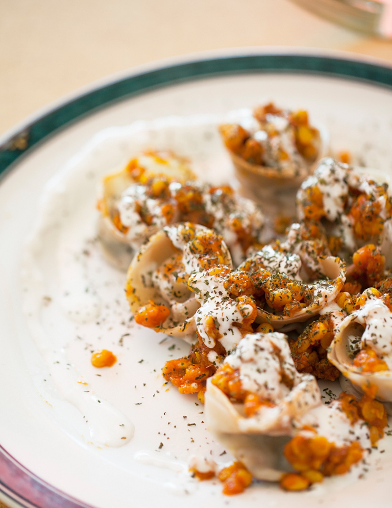 Muntoo is steamed dumplings stuffed with ground beef and onions, then topped with lentils, beef, garlic yogurt and mint.