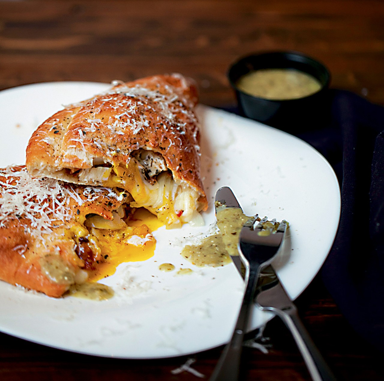 The "Which Came First...?" calzone is filled with roasted pulled chicken, applewood-smoked bacon, jalapenos, egg, onion and mozzarella. It is served with a salsa verde.