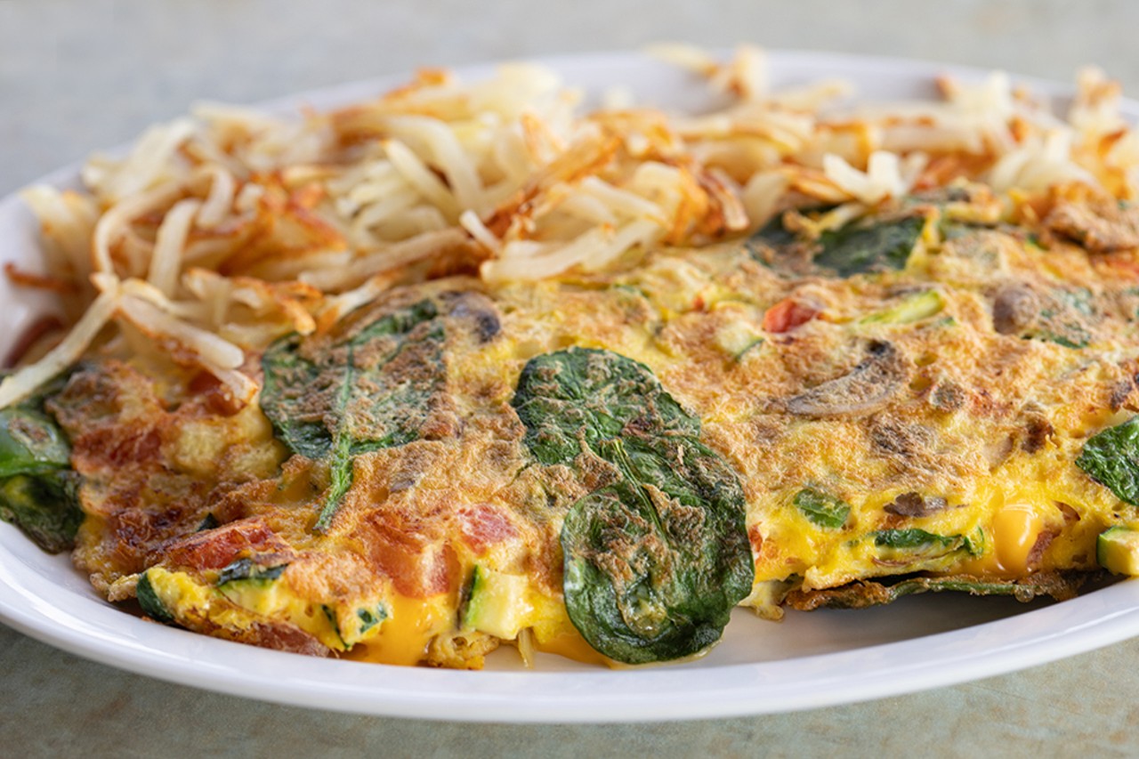 Garden omelet with hash browns, zucchini, onions, mushrooms, green peppers, spinach, cheddar and three eggs.
