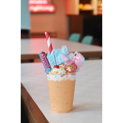 The Cotton Candy Freak Shake is a Creamsicle shake topped with cotton candy, SweeTarts, a Super Blow Pop, whipped cream and a cherry.