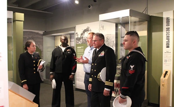 Mikall Venso, military and firearms curator for the Missouri Historical Society and chief curator of Vietnam: At War and At Home, leads a tour through the exhibit.