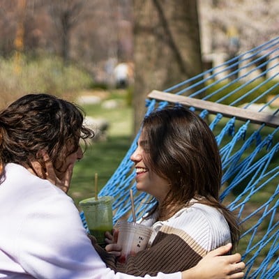 Ro Abouantoun, left, and Rachel Zilligen sit on a hammock at Saint Louis University.