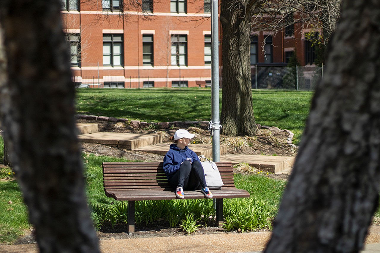 A person enjoys quiet reflection on the campus of Saint Louis University.