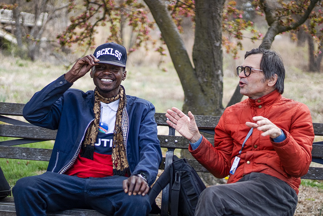Michael Ross, left, talks with his social worker on a bench in Forest Park.