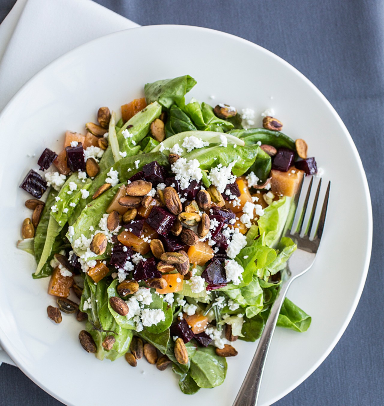 Roasted beet and local green salad is topped with blood orange vinaigrette, goat cheese and toasted pistachios.