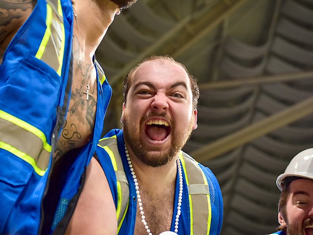 A man screams into the camera with his mouth wide open.