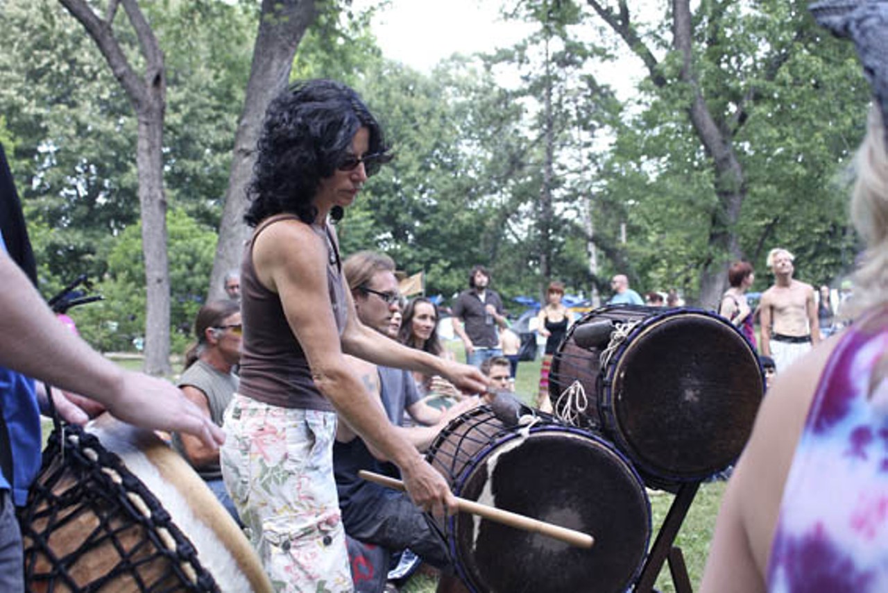 Attendees of the picnic form a drum circle.